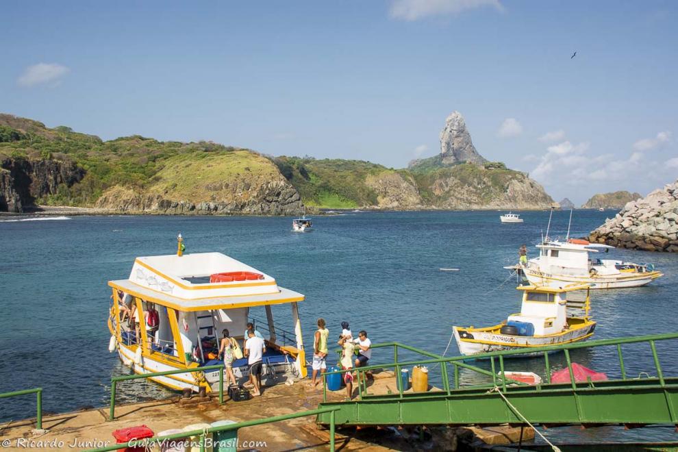Imagem de turistas entrando no barco para passeio em Fernando de Noronha.
